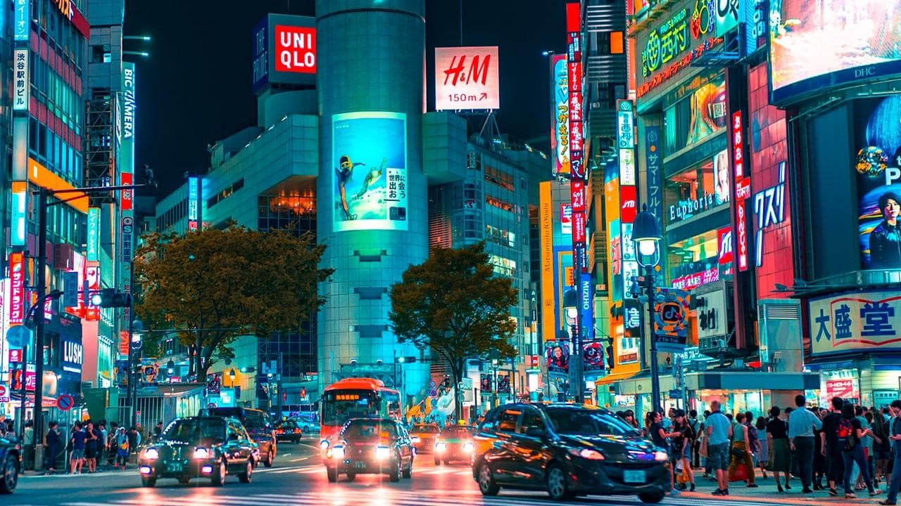 夜晚日本一条繁忙街道上的数字广告板。